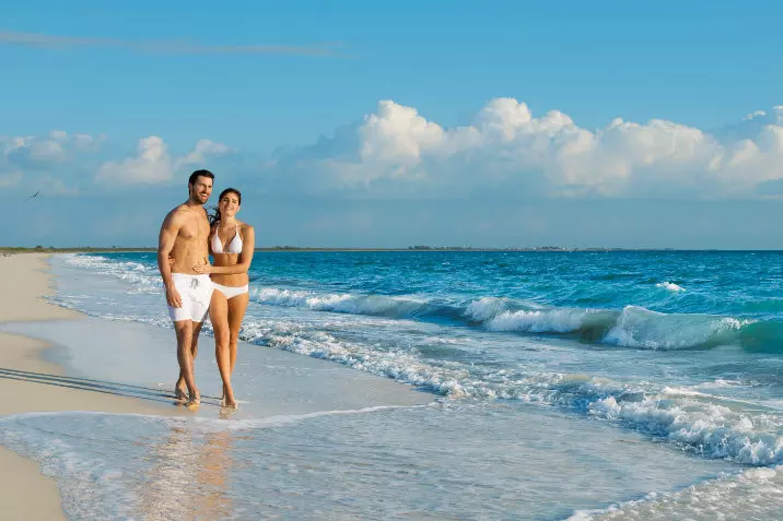 Couple amoureux marchant sur la plage de l'hôtel Secrets Playa Mujeres Mexique